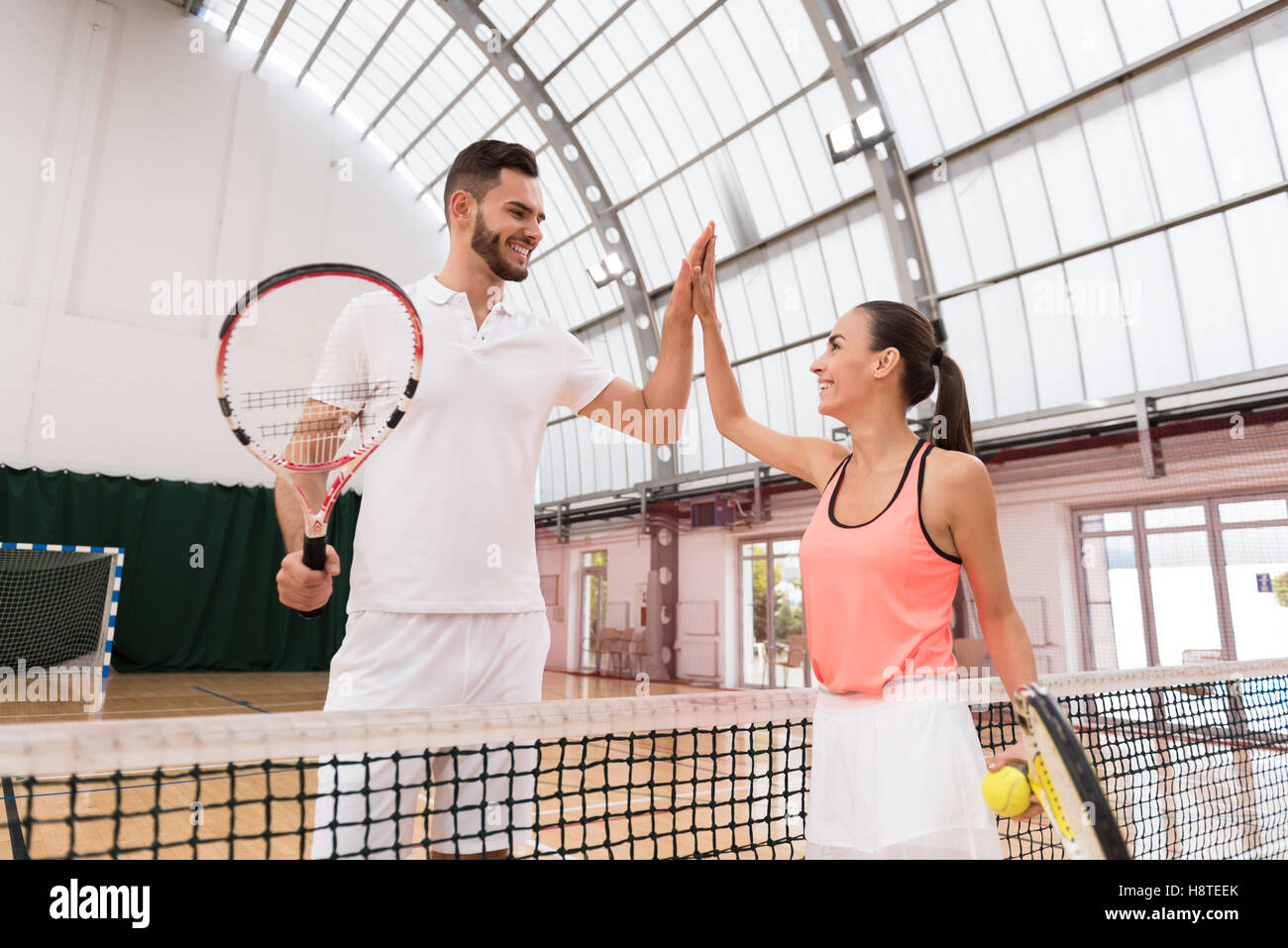 Positive tennis players giving high five Stock Photo - Alamy