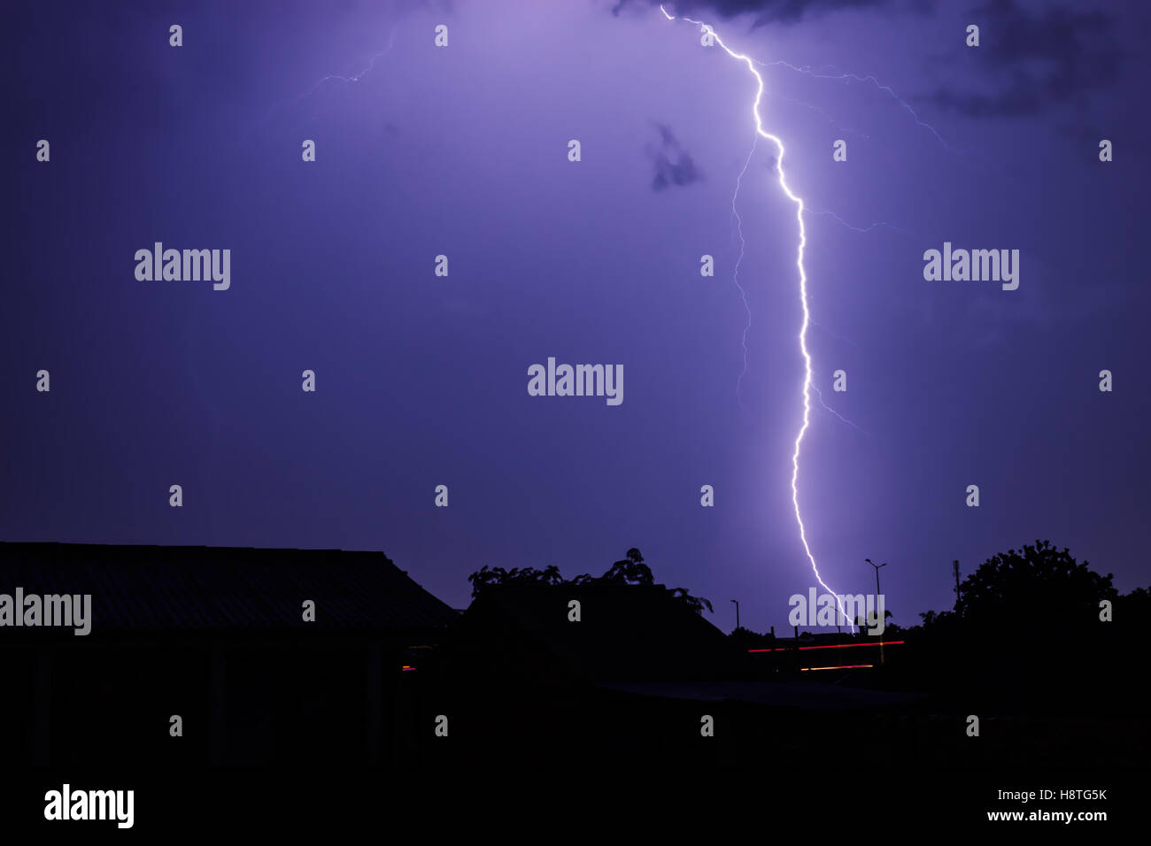 Silhouette of a landscape when lightning storm flashes in the sky of