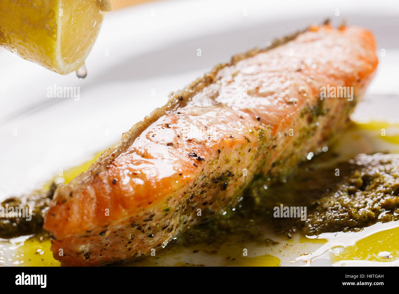Crisp Salmon Steak with pesto Sauce to top drop lemon Stock Photo Alamy