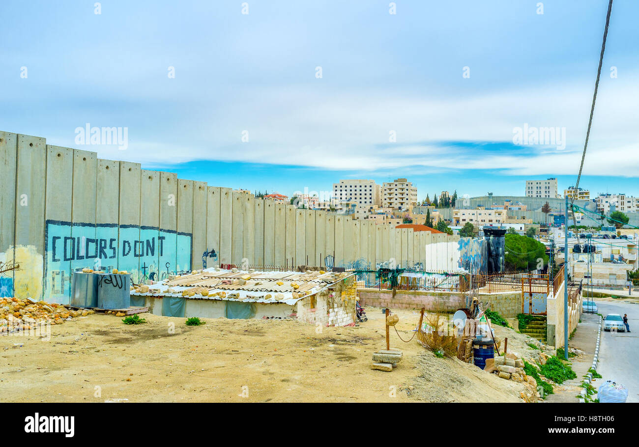 The living building next to the separation wall is a part of the refugee camp Stock Photo