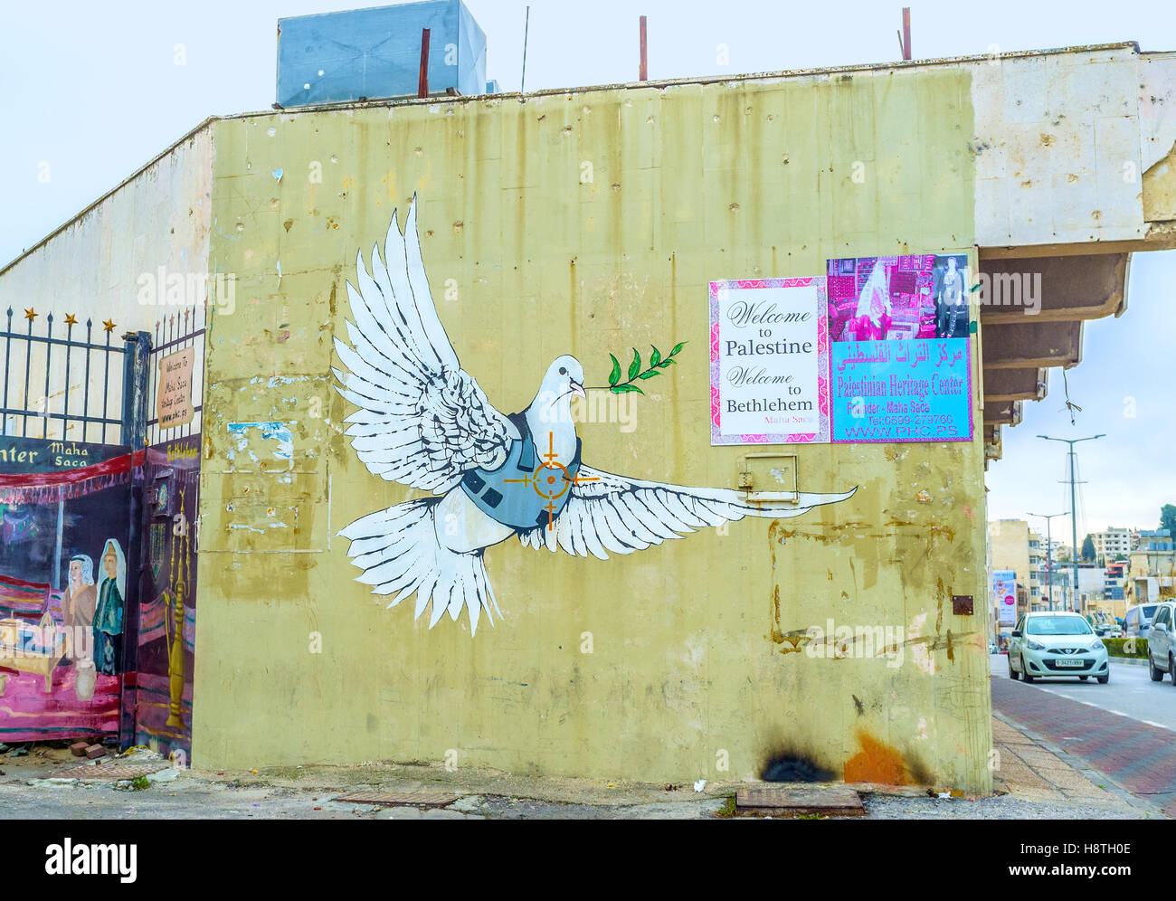 The mural of dove of peace dressed in a body armor with the aim on its heart painted on the wall of the house Stock Photo