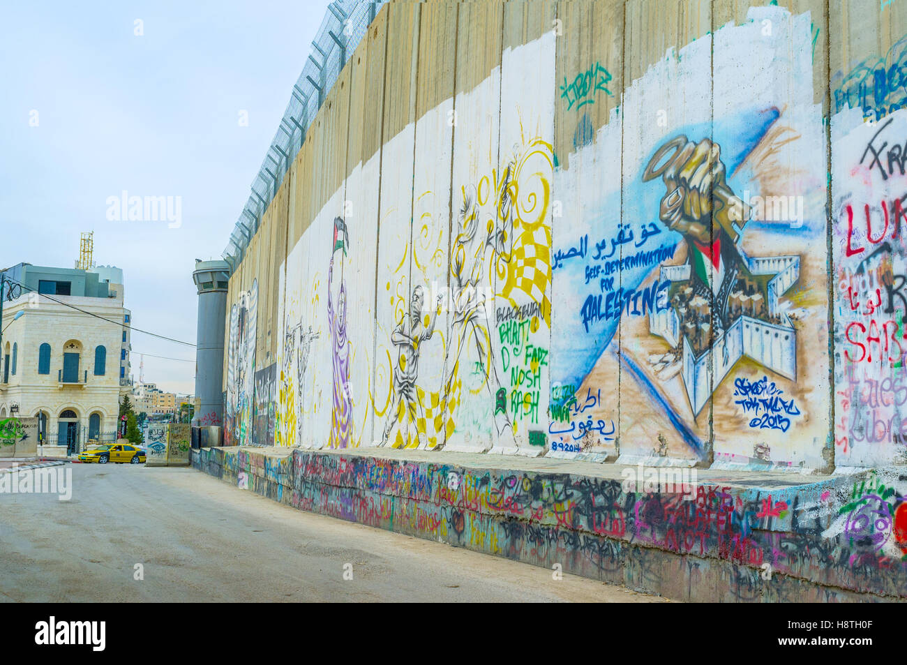 The separation wall becomes the place for street murals , that shows the author's point of view on the realities of the life Stock Photo