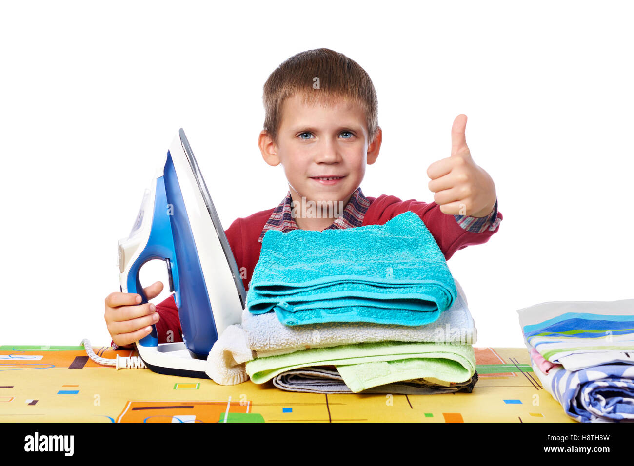 Boy with washed linen around the ironing board with iron isolated white Stock Photo