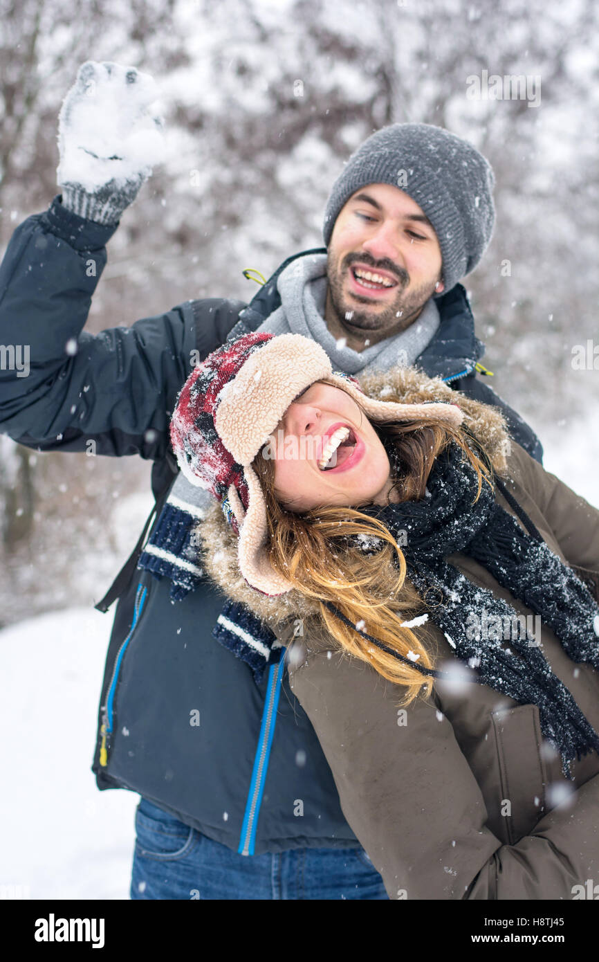 Couple having fun in a snow covered park Stock Photo