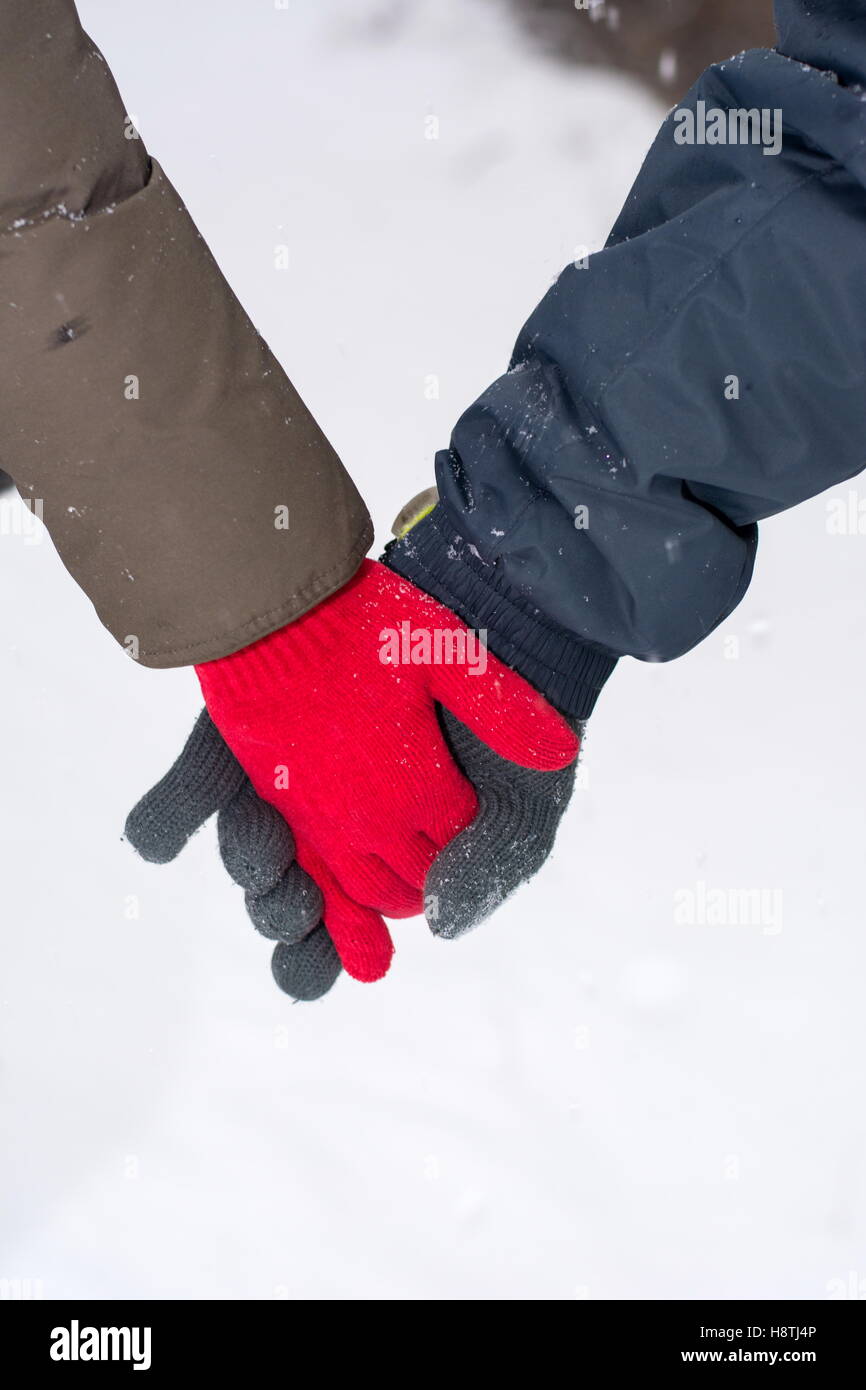 Couple holding hands in a snow covered park Stock Photo
