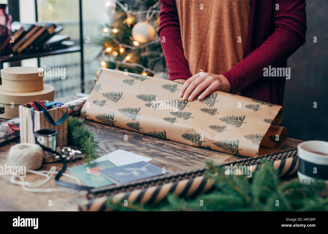 Woman Wrapping and Decorating Christmas Present Stock Photo