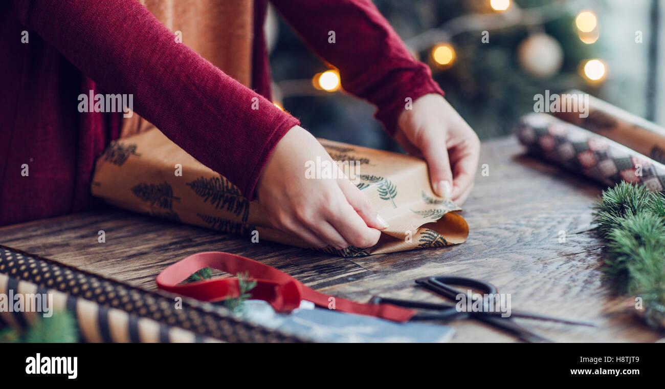 Woman Wrapping and Decorating Christmas Present Stock Photo