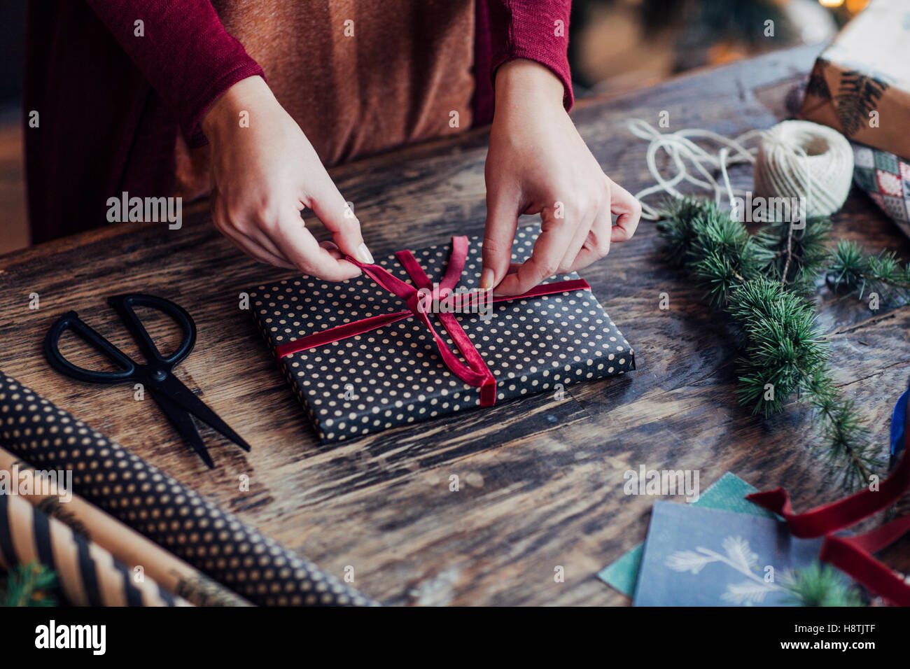 Woman Tying Ribbon on Christmas Present Stock Photo Alamy