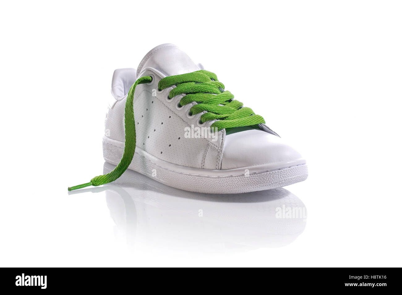 White sneaker with green laces on white 