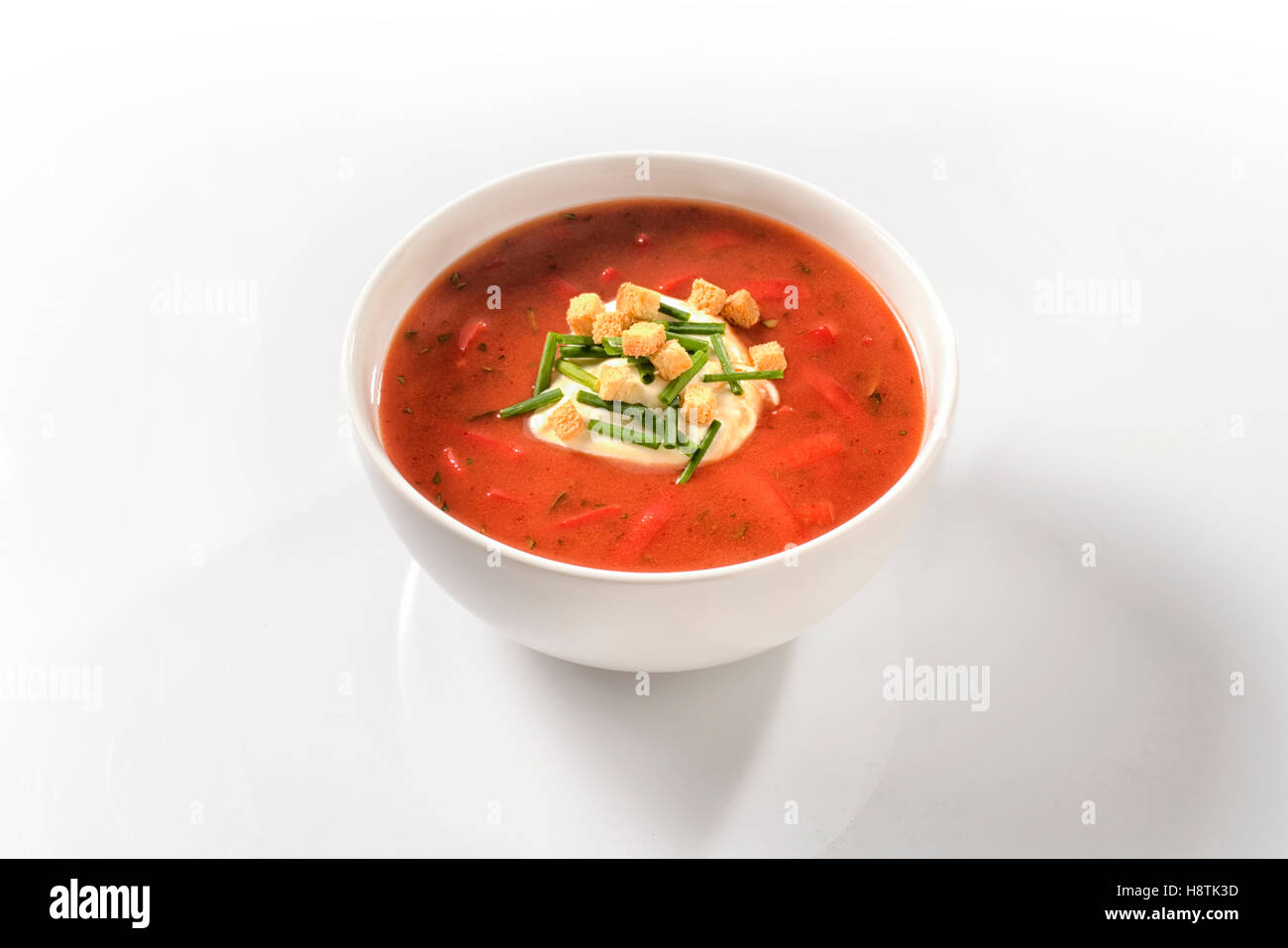 Sweet pepper soup with peppers and sour cream in a white porcelain cup Stock Photo
