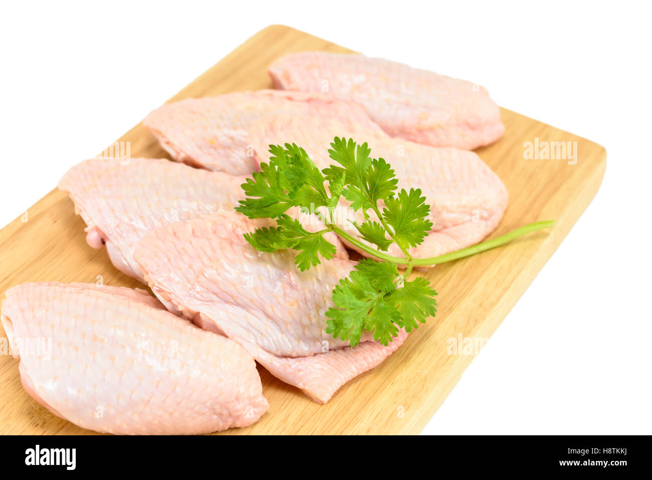 closeup and detail raw chicken wings with green coriander on a cutting