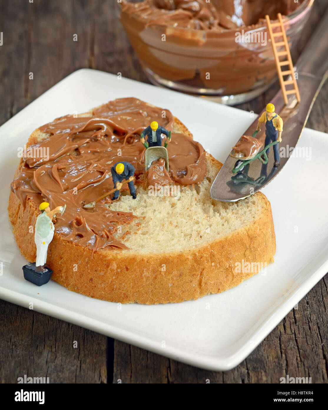 minifigure workers  on bread and chocolate cream Stock Photo