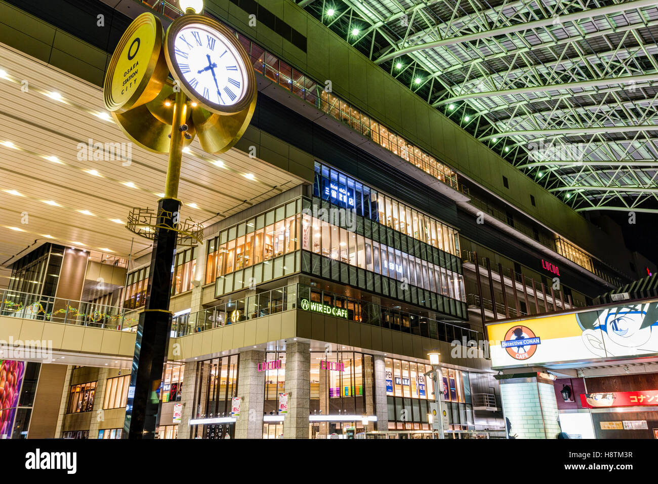 Japan, Osaka Station City Interior. Taki-no-hiroba Plaza, public concourse with clock and North Gate Building, shops, and entrance. Night time. Stock Photo