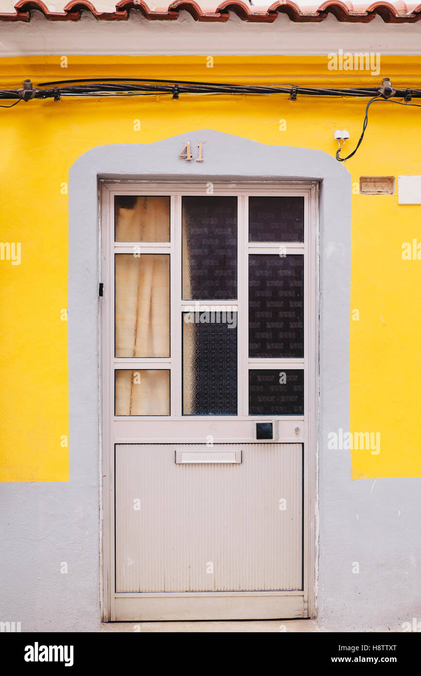 front door in yellow and grey wall Stock Photo
