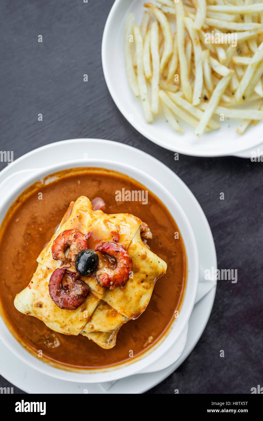 famous francesinha traditional meat cheese and spicy sauce grilled sandwich of porto portugal Stock Photo
