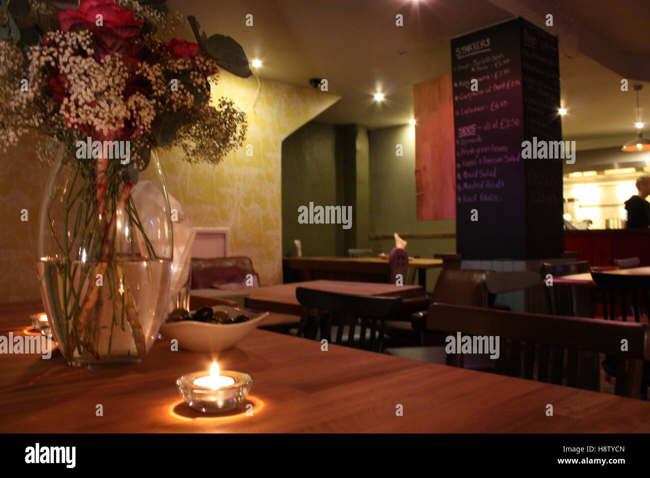Flowers In A Pub Dining Room Restaurant Setting With A Candle