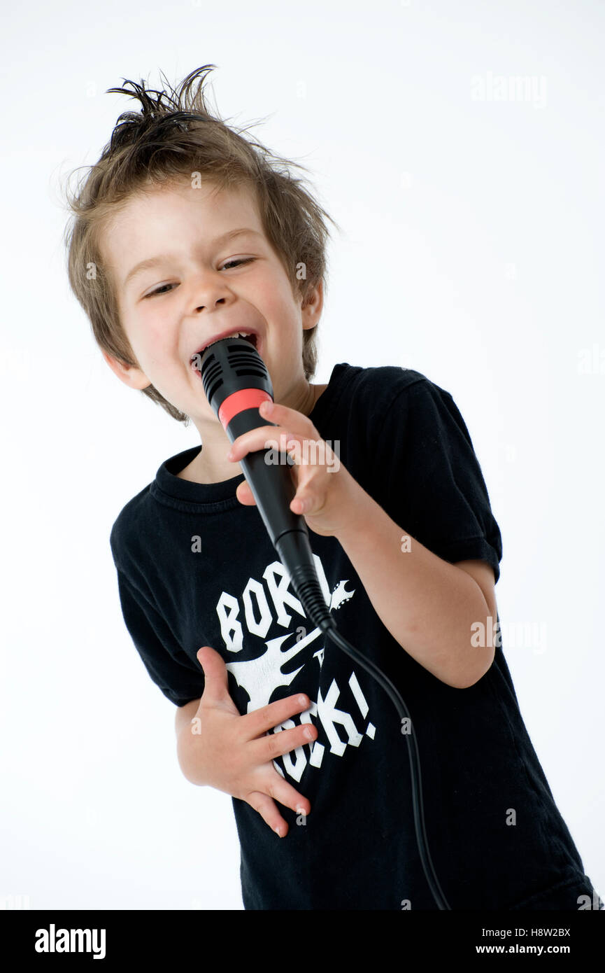 Boy, 4 years old, singing into a microphone Stock Photo