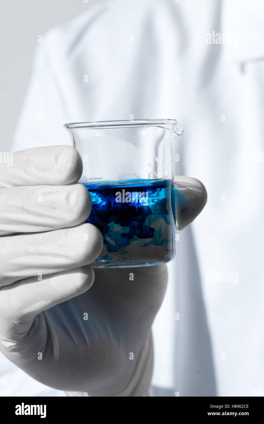 Beaker Food Coloring Rwd Chemistry lab measuring cup beaker in hands with blue food coloring ...