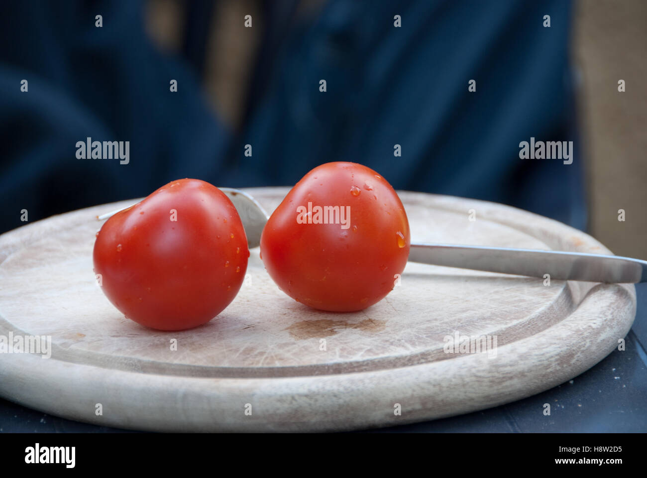 Two tomatoes on a cutting board Stock Photo - Alamy
