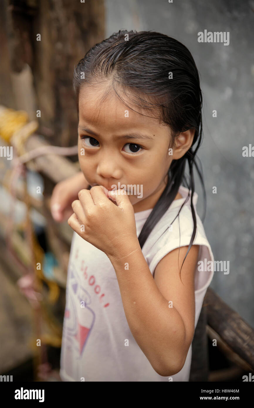 PUERTO PRINCESA,PHILIPPINES-OCTOBER 19,2016: Little girl plays in front of family trade on October 19, Palawan,Philippines. Stock Photo
