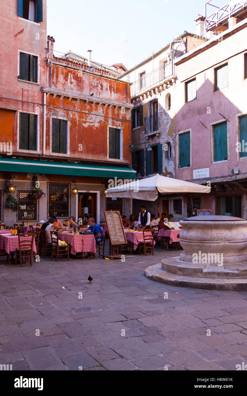 A Cafe' in an old square in Venice showing customer sitting at tables outside Stock Photo