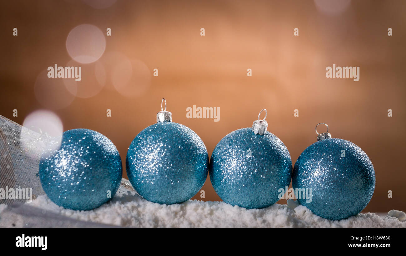 Four turquoise Christmas baubles on snow. Xmas greeting card. Stock Photo