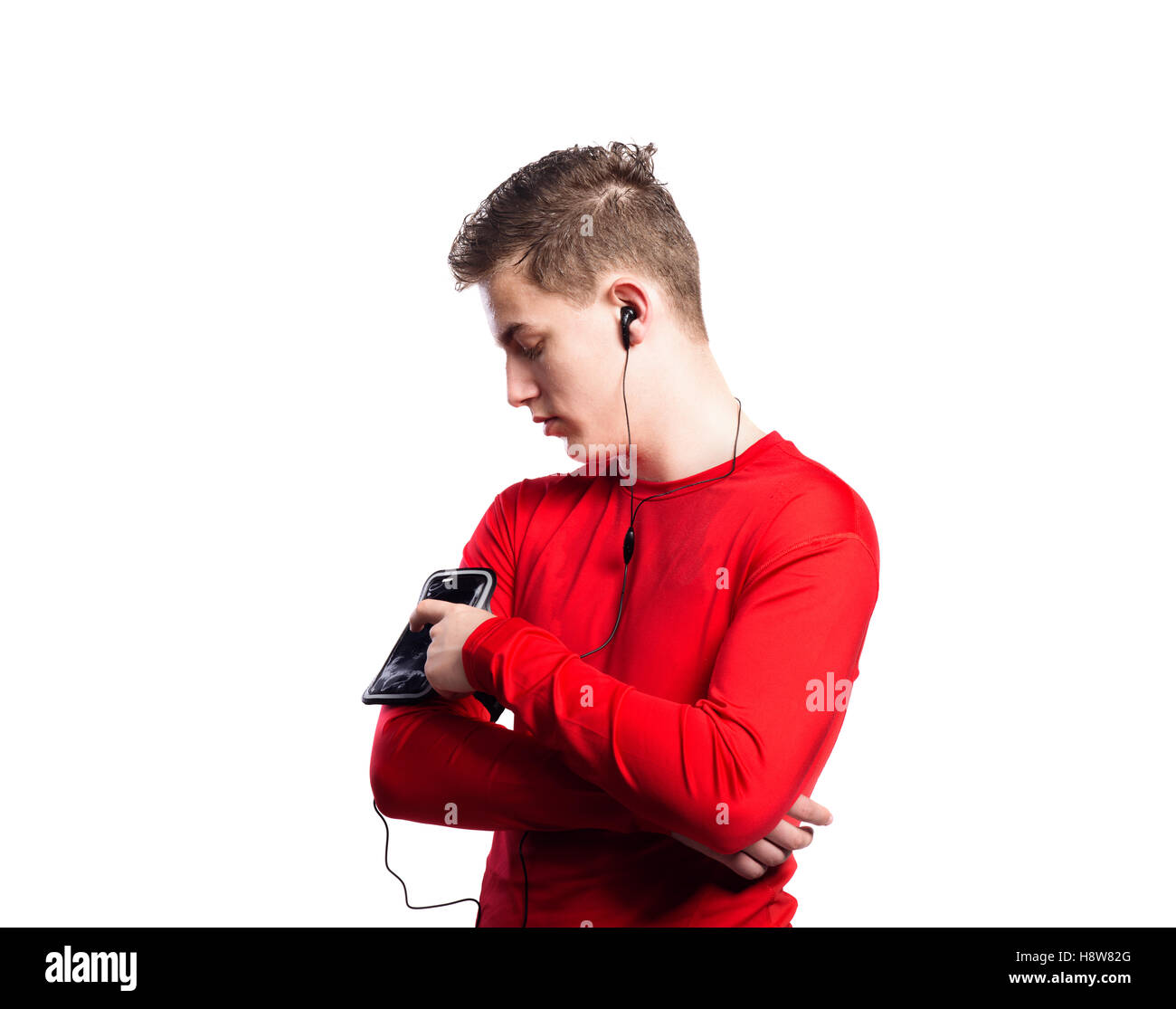 Teenage boy with smartphone and earphones. Studio shot, isolated Stock Photo