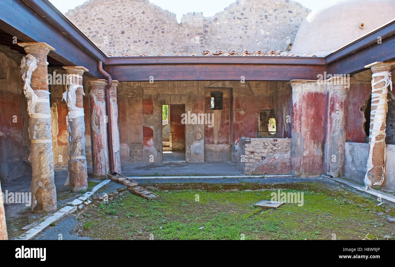 The ancient courtyard of the Roman villa with painted walls and columns, Pompeii, Italy. Stock Photo