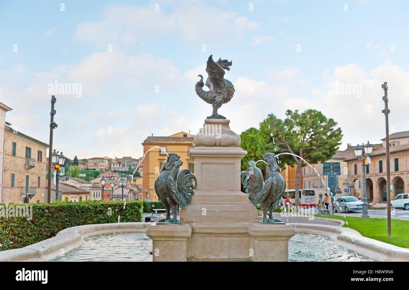 The bronze winged serpent topped the fountain with roosters in the green garden Stock Photo