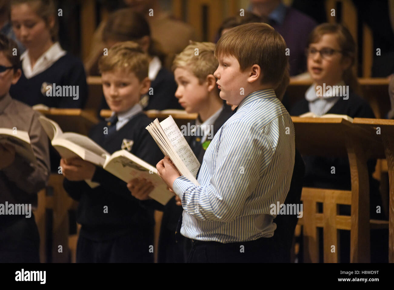 Choristers being conducted by choir master at a recording session for a commercial CD production. Inside wells Cathedral. Stock Photo