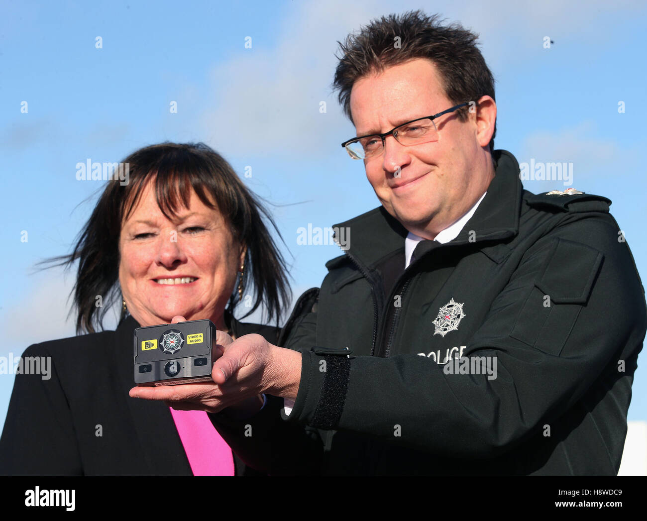 Chief Superintendent Chris Noble and Chair of the Policing Board Anne Connolly look at a body worn video camera at a Police Service of Northern Ireland media briefing at Musgrave Police Station about the introduction of the cameras for police officers across Belfast. Stock Photo