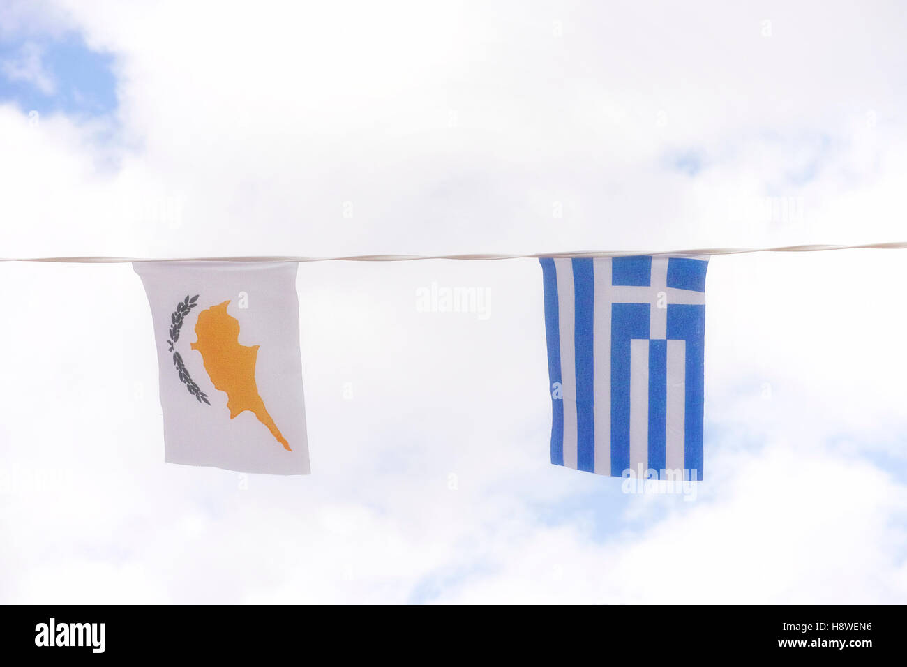 Greece and Cyprus flags against blue cloudy sky. Close up. Stock Photo