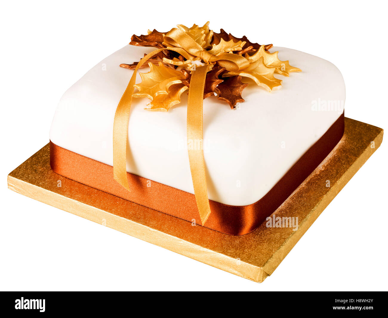 Traditional Authentic Iced and Decorated Rich Fruit Christmas Cake With Gold Ribbons And Holly On A Cake Board With No People Ready To Eat Stock Photo