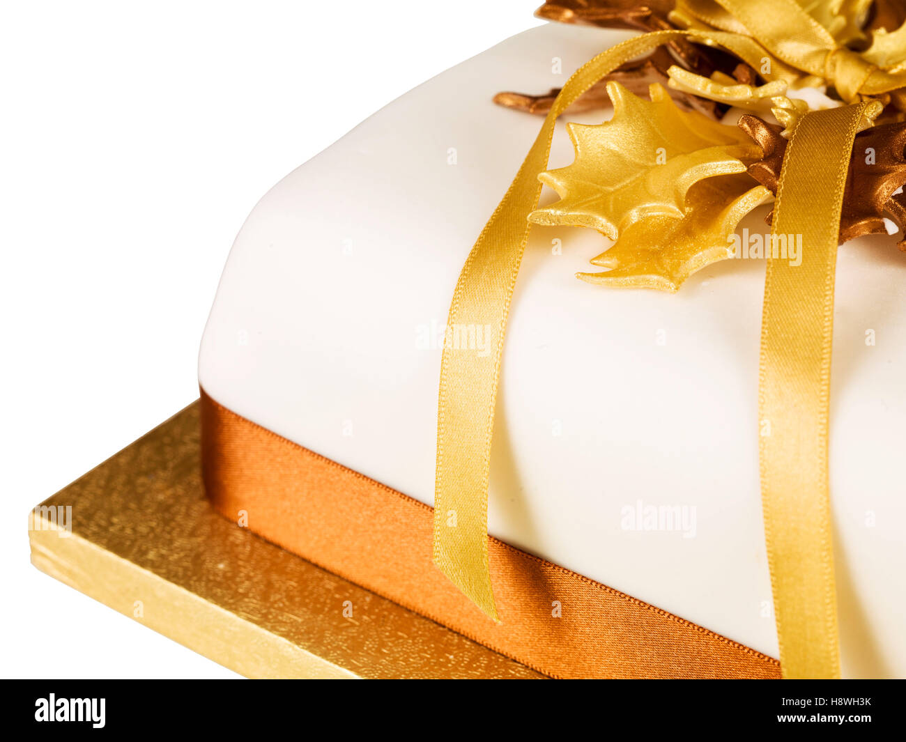 Traditional Authentic Iced and Decorated Rich Fruit Christmas Cake With Gold Ribbons And Holly On A Cake Board With No People Ready To Eat Stock Photo