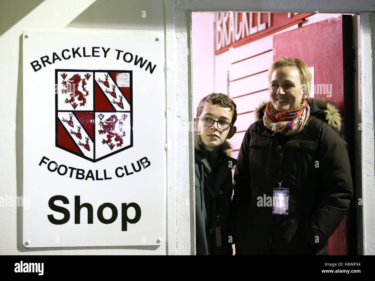 Brackley Town staff watch from the club shop during the FA Cup First Round Replay at St James Park, Brackley. Stock Photo