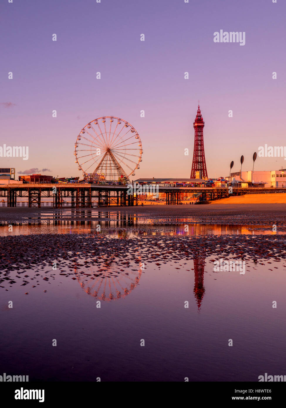 Blackpool Tower and Central Pier with reflection in water on beach at sunset, Lancashire, UK. Stock Photo