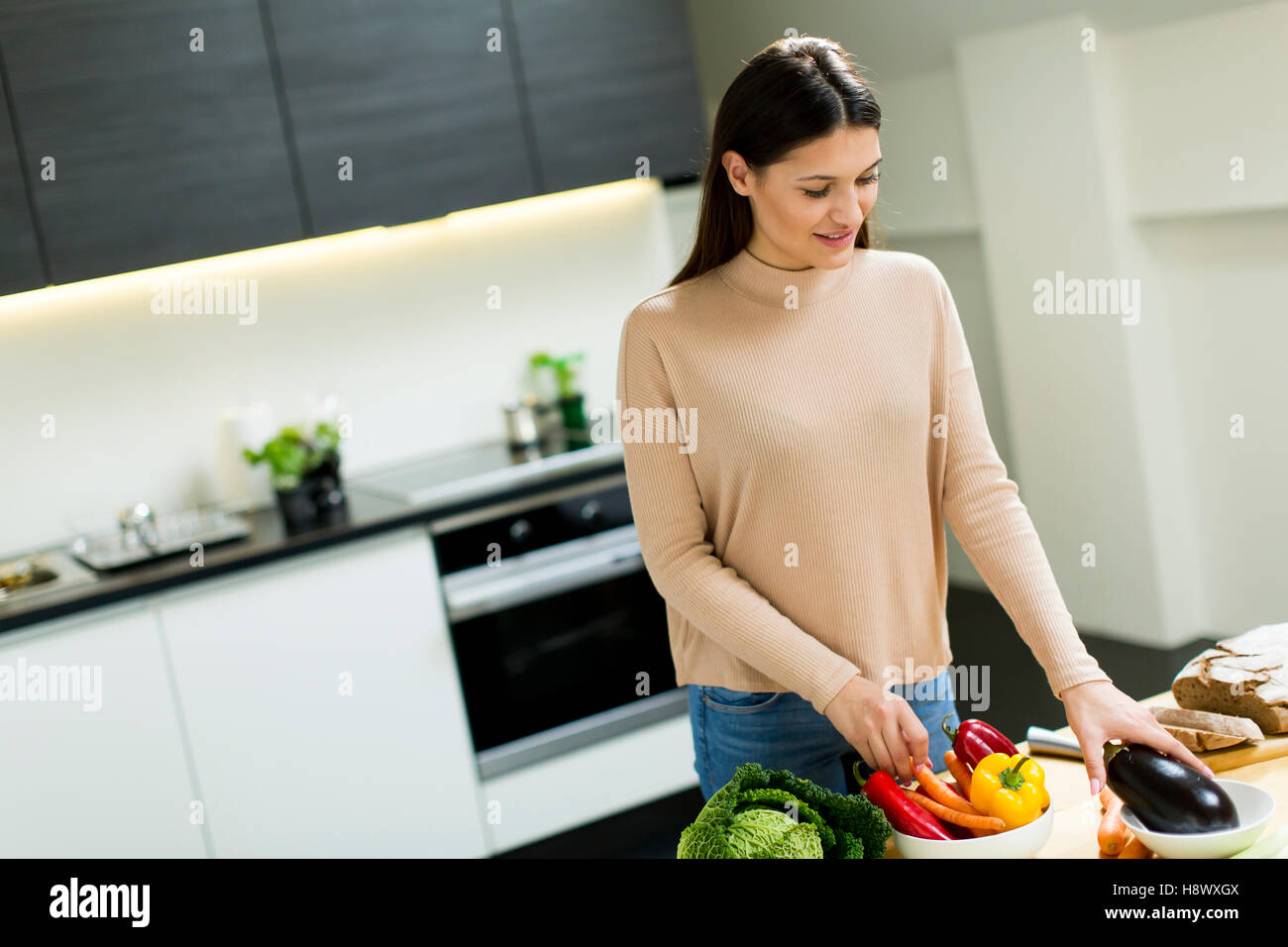 Pretty young woman preparing food in the modern kitchen Stock Photo