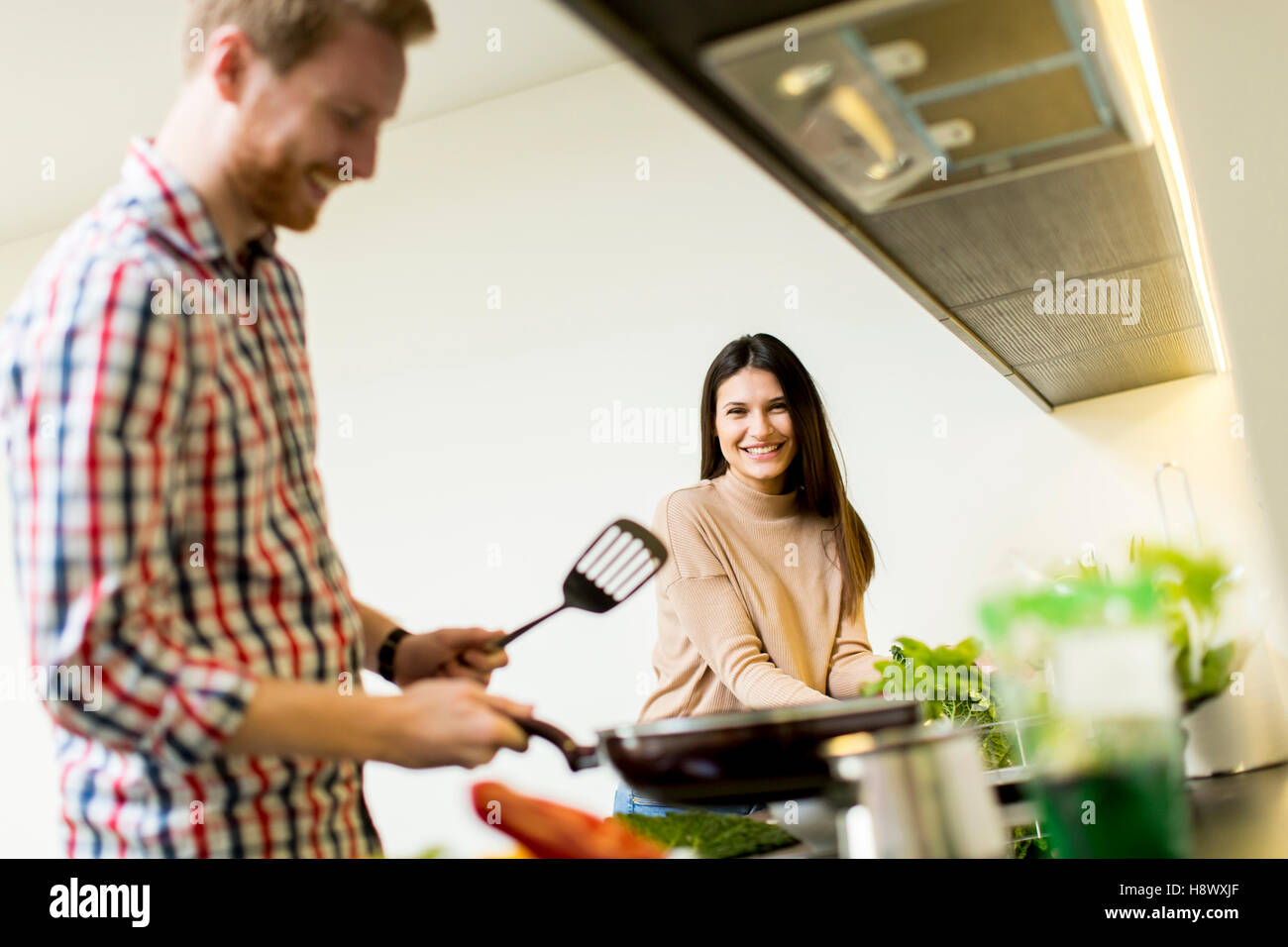 Happy young couple preparing food in the kitchen Stock Photo