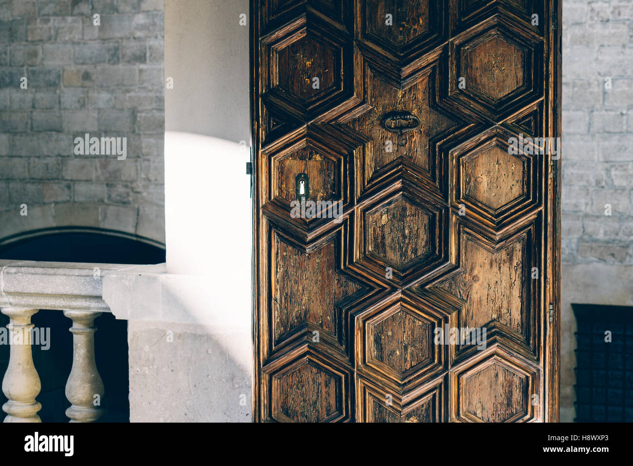 An old decorative heavy wooden door in a stone building. Stock Photo