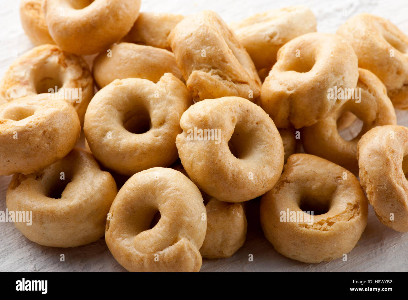 Pile of crunchy Italian taralli crackers for a tasty finger snack in a close up view on a white board Stock Photo