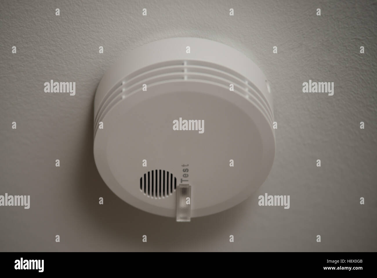 Smoke detector on white ceiling with test button Stock Photo Alamy