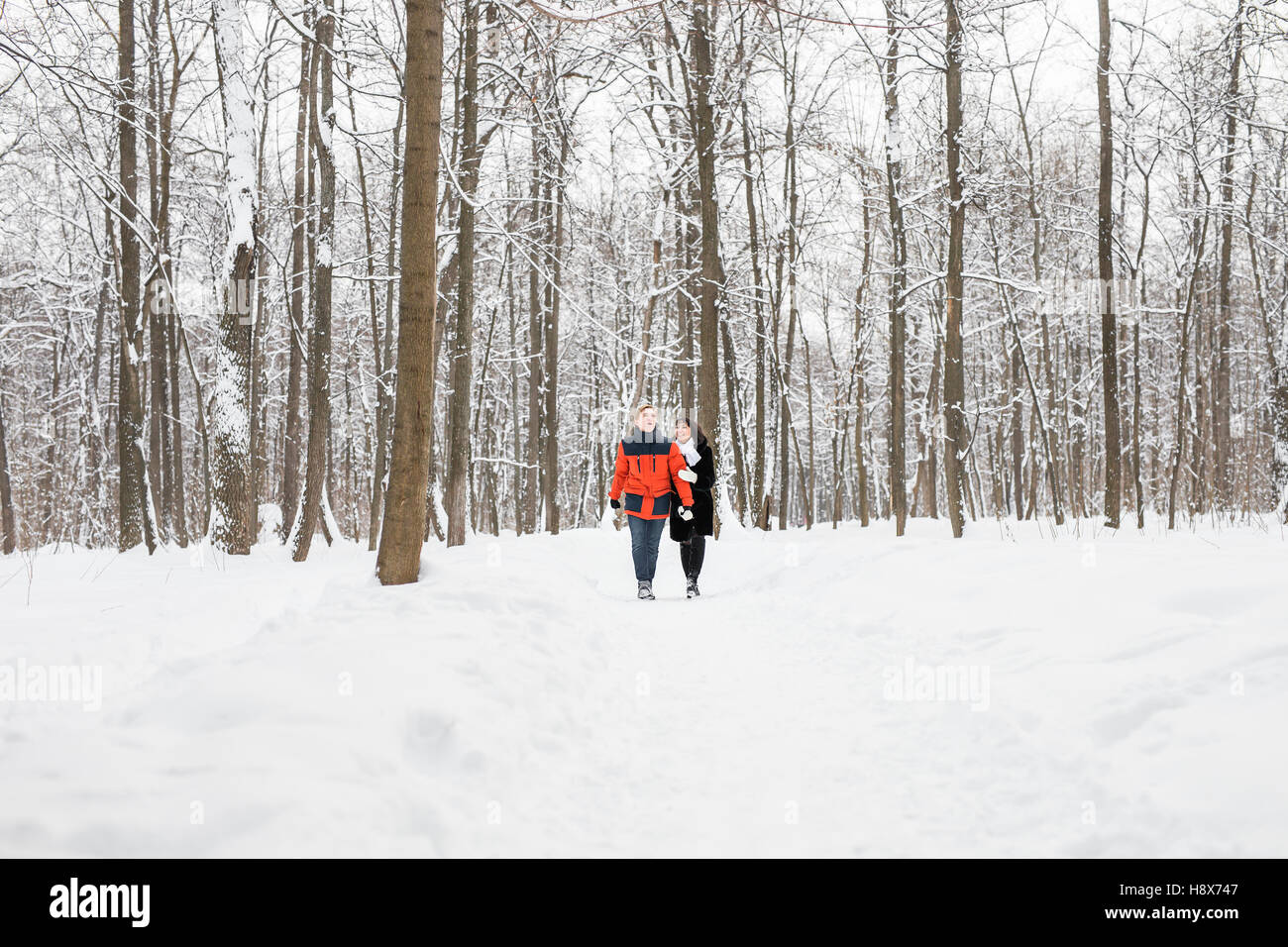 happy couple walking through a snowy forest in winter Stock Photo - Alamy
