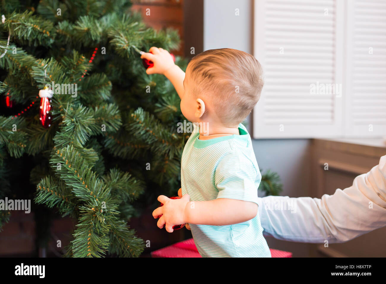 Dectrorting Little Tree little boy decorating the Christmas tree at home Stock Photo - Alamy