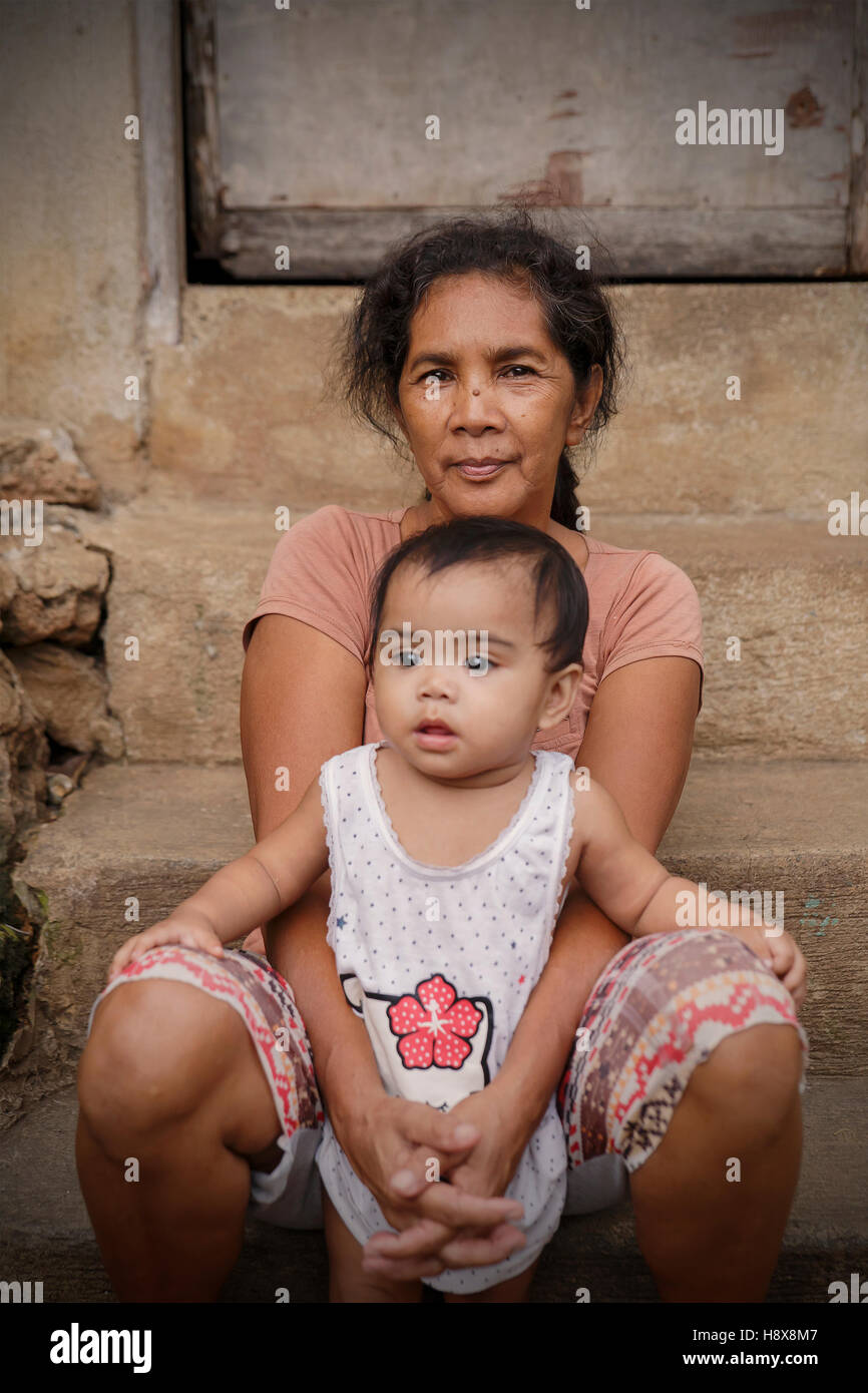 PUERTO PRINCESA,PHILIPPINES-OCTOBER 19,2016: Mother takes care of her baby at the entrance to her home on October 19, Palawan,Ph Stock Photo