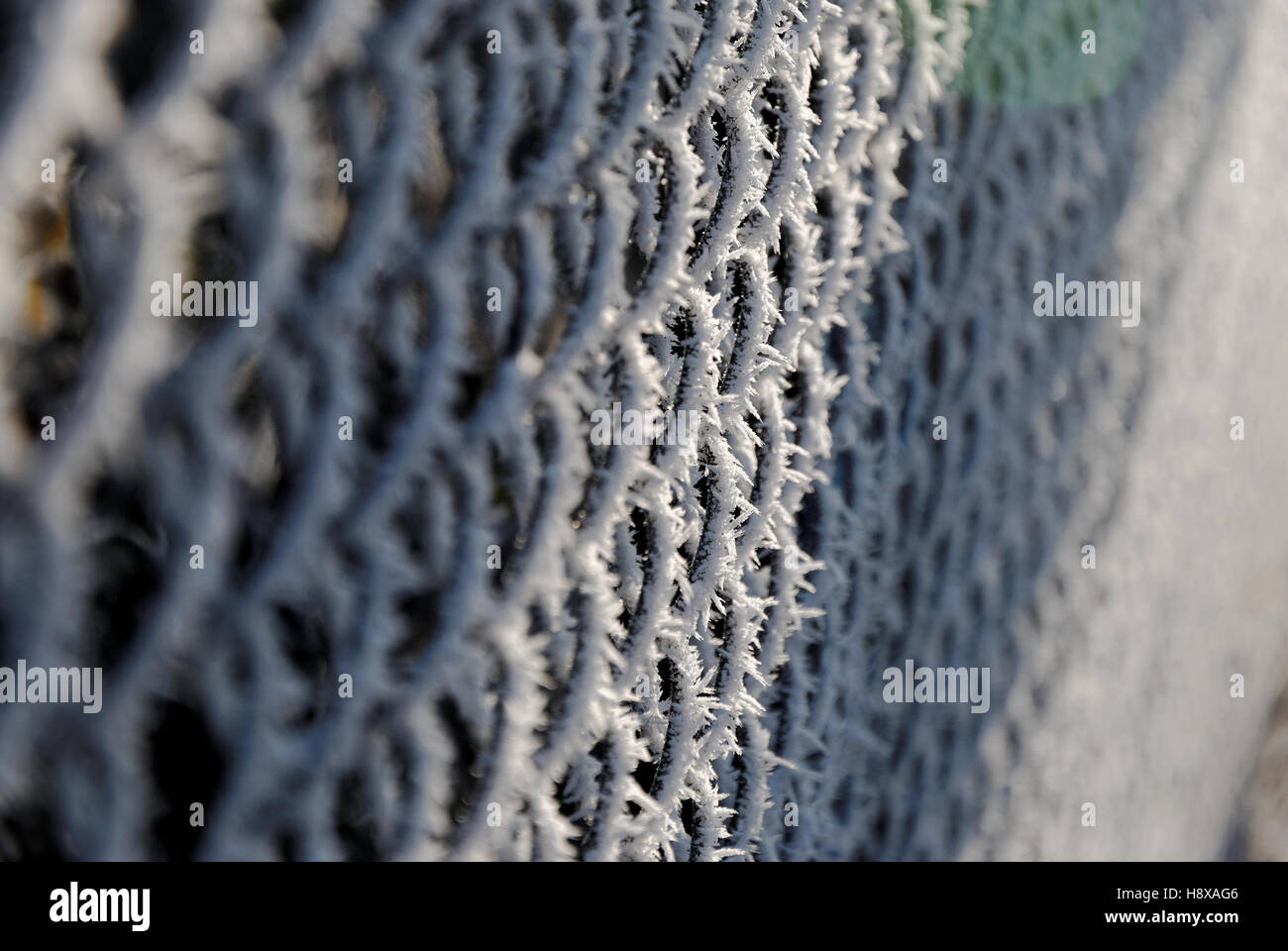 Chain link fence covered with white snow at sunrise Stock Photo - Alamy