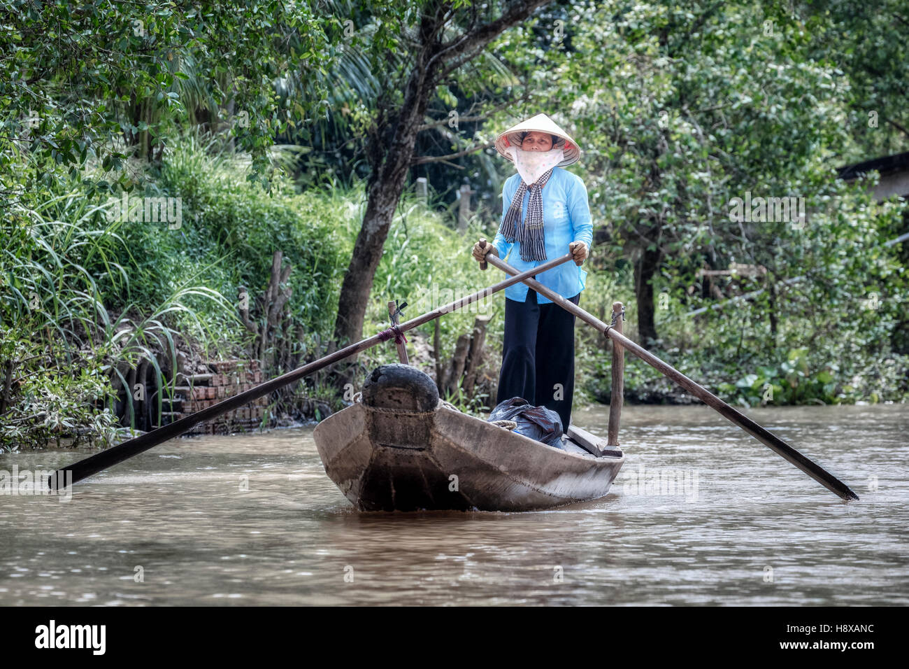 woman rowing a sampan boat on the Mekong River in Cai Be, Mekong Delta, Vietnam, Asia Stock Photo