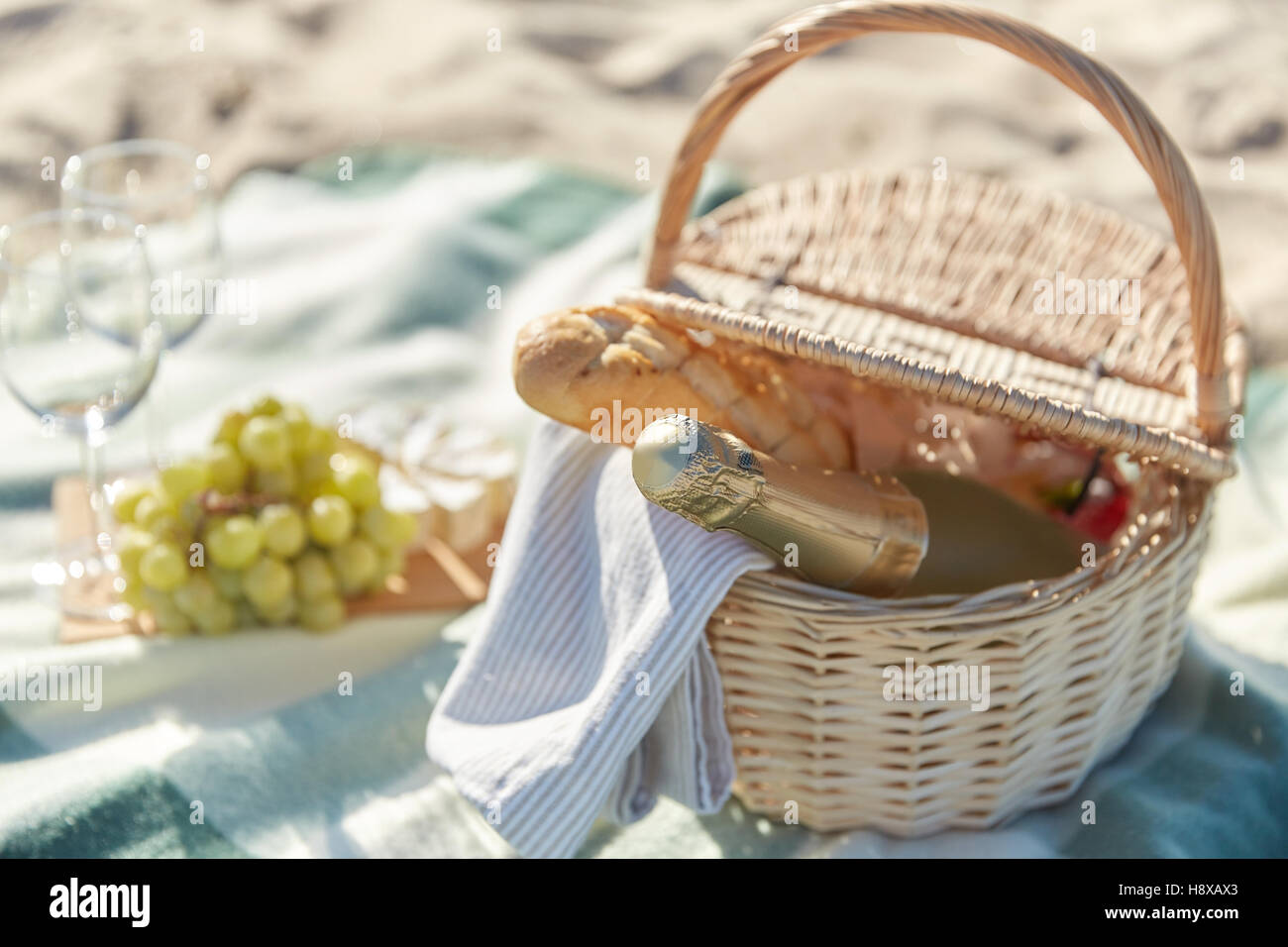picnic basket with wine glasses and food on beach Stock Photo Alamy