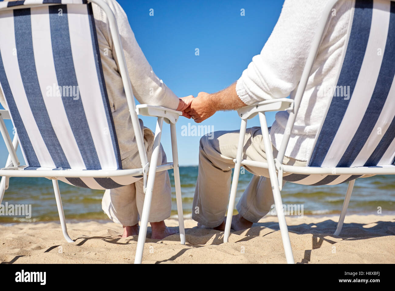 senior couple sitting on chairs at summer beach Stock Photo - Alamy