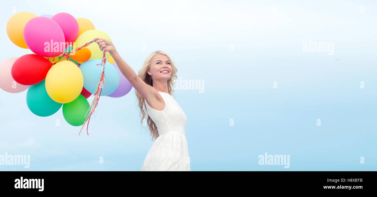 smiling woman with colorful balloons outside Stock Photo