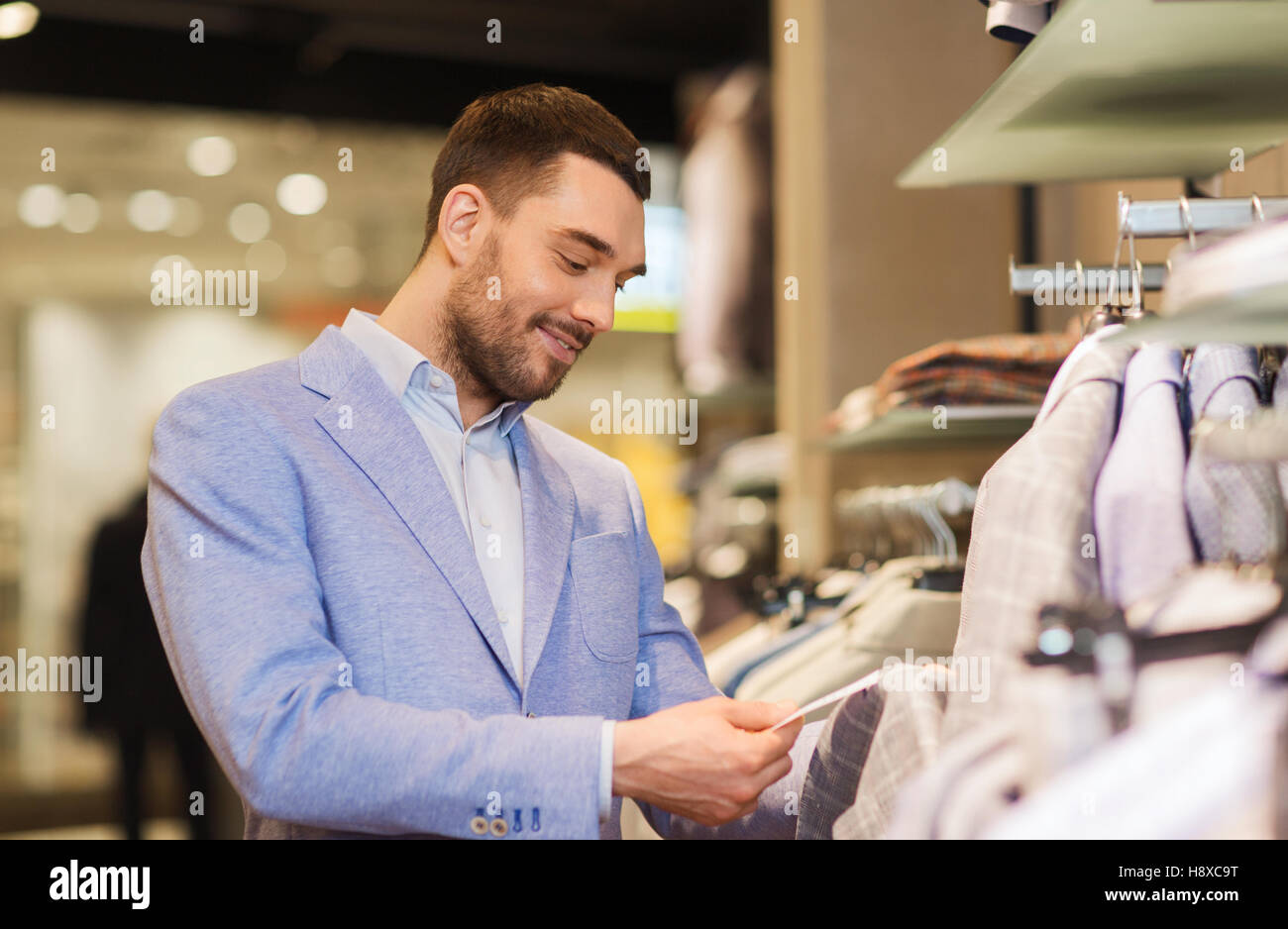 happy young man choosing clothes in clothing store Stock Photo - Alamy